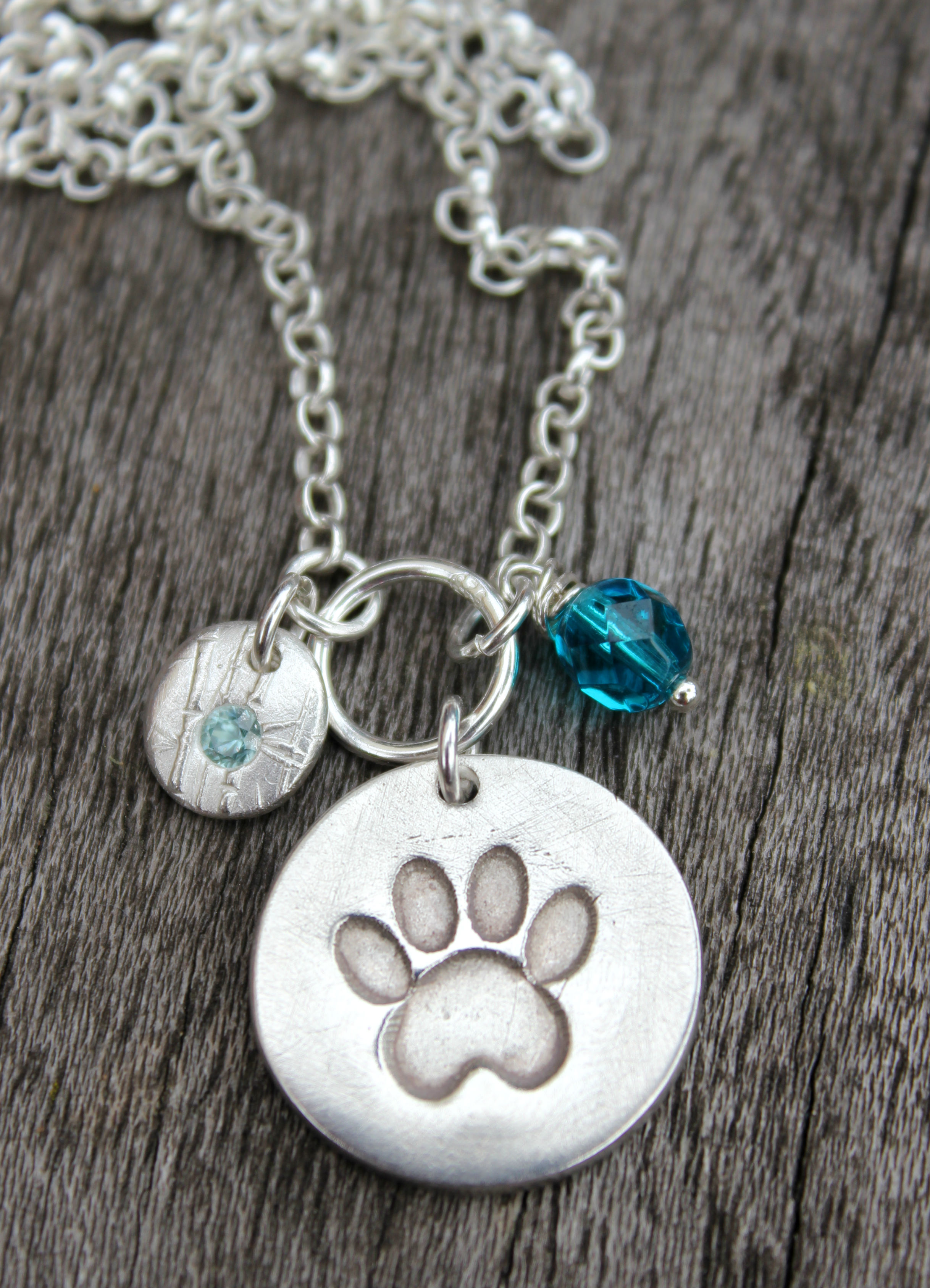 Paw print pendant with blue zircon pebble.JPG